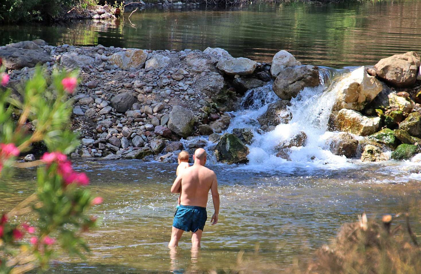 Un padre se baña con su pequeño en el río Guadiaro. Foto Karl Smallman.