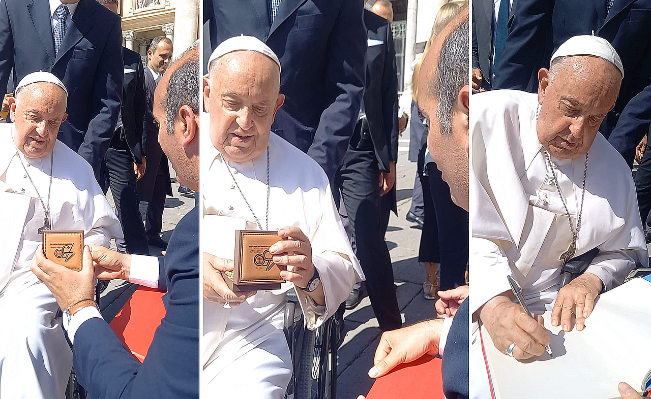Momento en el que el Papa recibe la medalla de honor de la hermandad y firma en el libro de honor.