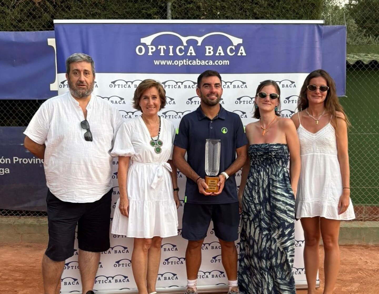 Momento en el que el ganador recibe el trofeo de manos de los responsables de Óptica Baca.