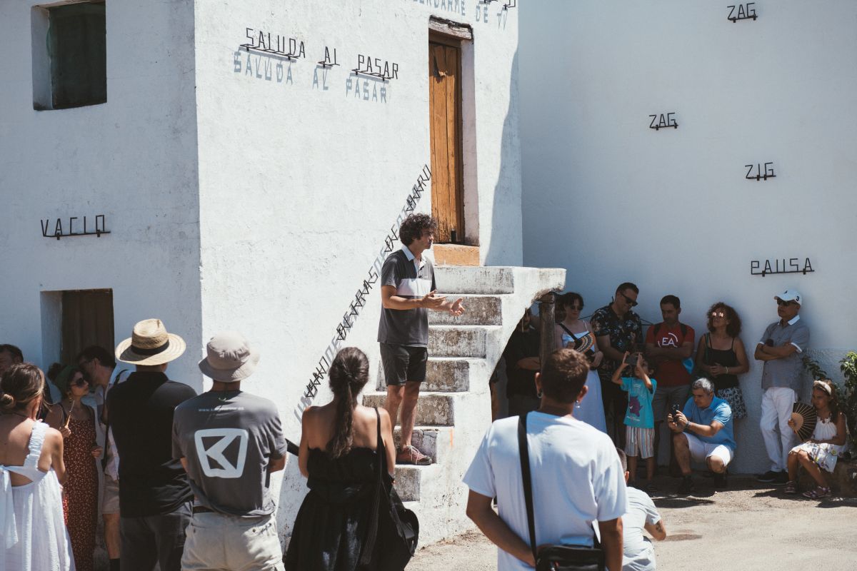 Luce, artista de la edición 2024, mostrando el resultado de su obra a vecinos y visitantes en Genalguacil.