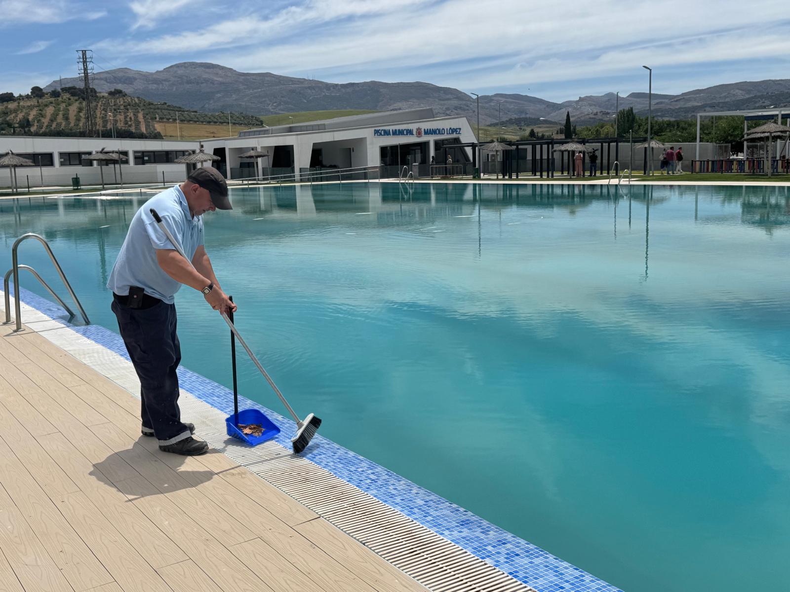 Operario limpiando la piscina municipal.