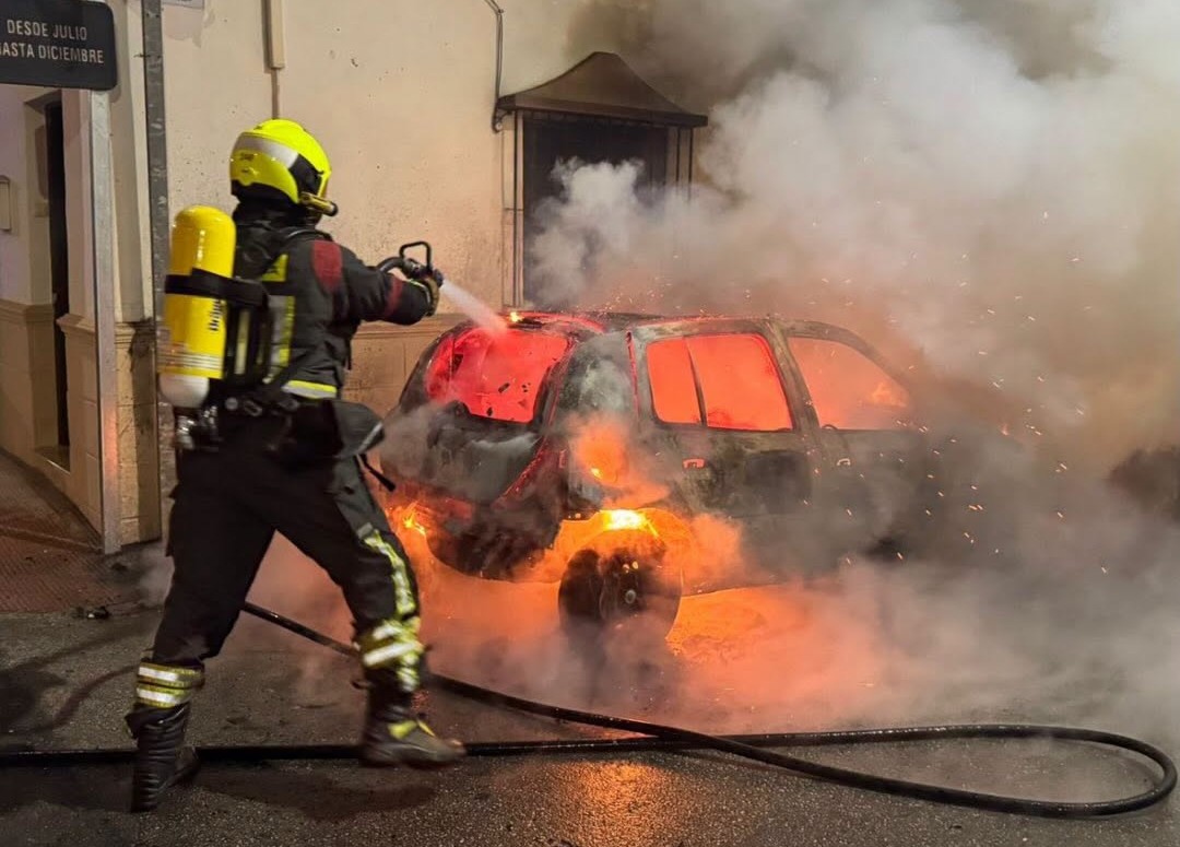 Momento en el que los bomberos de Ronda sofocan las llamas en uno de los turismos.
