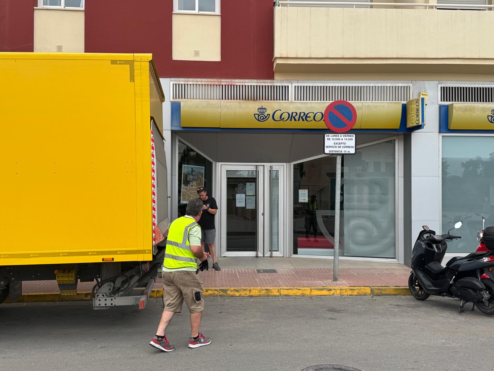 Dos ciudadanos haciendo uso de la oficina de Correos en la barriada UE-19.